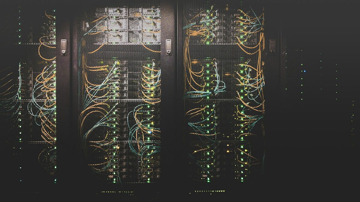 Deretan rak server di sebuah pusat data, tempat paket hosting kamu sebenarnya berjalan (kredit: Unsplash/Taylor Vick)
